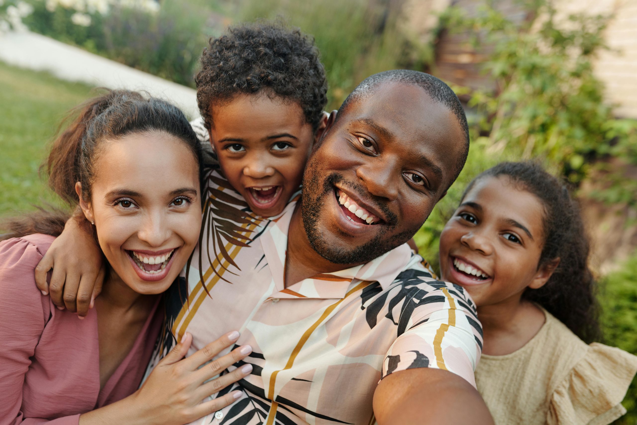 a-joyful-multicultural-family-taking-a-selfie-outdoors-in-a-lush-garden-setting-3BuI7113of_88VPuM8SjEA